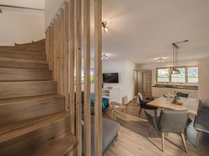 ein Esszimmer und ein Wohnzimmer mit einer Treppe in einem Haus in der Unterkunft Vergissmeinnicht in Schwendau