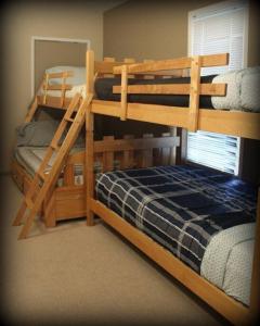 a bedroom with two bunk beds and a ladder at Grand Beach Lodge in Grand Beach