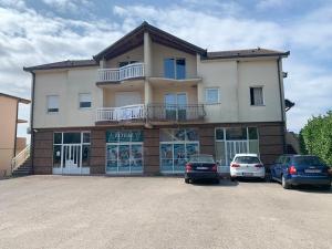 un gran edificio con coches estacionados en un estacionamiento en Maslina Apartments, en Široki Brijeg