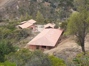 a group of houses on a hill with trees at Hotel Suamena in Ráquira