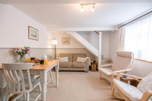 a living room with a table and a couch at North Cottage, Alderton in Woodbridge +15 photos