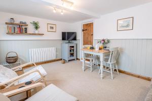 a living room with a table and a stove at North Cottage, Alderton in Woodbridge