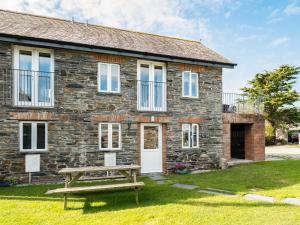 a stone cottage with a picnic table in front of it at Swallow Cottage, Trewetha Farm in Port Isaac