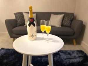 una botella de champán y dos copas de vino en una mesa en Private Luxury Room Southampton, en Southampton