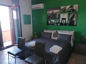 a green bedroom with a bed and two chairs at B&b Cilento Paestum in Paestum
