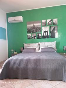 a green wall with a bed in a bedroom at B&b Cilento Paestum in Paestum