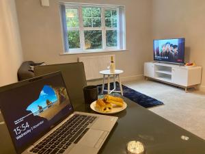 een laptop computer op een bureau met een bord eten bij Private Luxury Room Southampton in Southampton