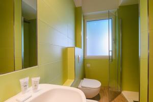 ein Badezimmer mit einem Waschbecken, einem WC und einem Spiegel in der Unterkunft Alessia' s Home in Tirano