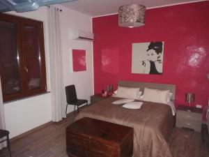 a bedroom with a bed with a red wall at B&b Cilento Paestum in Paestum