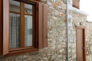 a window of a stone building with wooden at Stone Mansion House in Skopelos Town