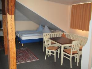Hotel AlleeSchlößchen في باد فيلدونجين: غرفة صغيرة بسرير وطاولة وكراسي