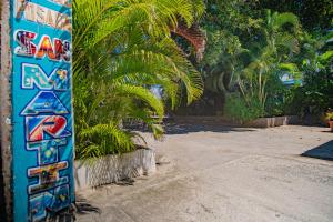 una pared azul con graffiti junto a las palmeras en Alojamiento San Martín, en San Andrés