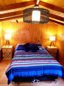 a bedroom with a bed and two lamps on tables at Cabaña Isla Negra in Isla Negra