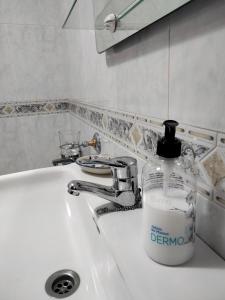 butelka detergentu na zlewie w łazience w obiekcie Apartamento en Terra do Porto con vistas w mieście O Grove