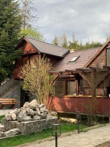 a house with a pile of rocks in front of it at Lucomi Chalet - For groups - 5 bedrooms in Poiana Ţapului