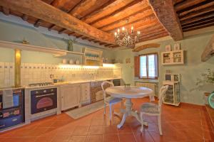 - une cuisine avec une table et des chaises dans la chambre dans l'établissement San Guido by PosarelliVillas, à Pelago