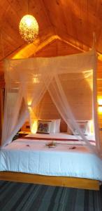 a bed with a canopy in a wooden room at Mc Queen Homestay in Ella