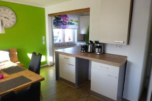 a kitchen with a counter and a green wall at Ferienwohnung Lorke in Thiersheim