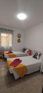 Zimmer mit 3 Betten in Gelb- und Weißtönen in der Unterkunft CASA FULVIO FUERTEVENTURA in Puerto del Rosario