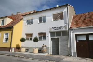 a building with a garage in a street at Apartments Freitag - H1 in Winden am See
