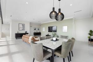 a dining room and living room with a table and chairs at Swainson at M1 in Adelaide