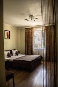 um quarto com uma cama e uma janela em Cocos Hotel em Rostov on Don