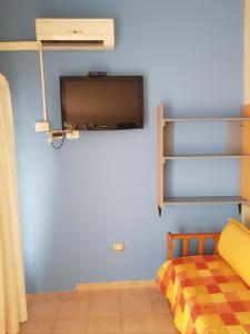 a bedroom with a bed and a tv on a wall at Terraza al Sol in Las Grutas