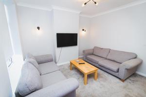 a living room with two couches and a table at Newly Refurbished House - 10 Minute Walk From City Centre in Norwich
