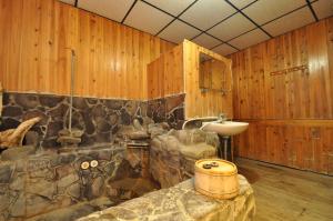 bagno con parete in pietra e lavandino di 四重溪洺泉溫泉旅館 a Checheng
