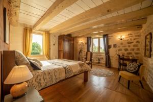 ein Schlafzimmer mit einem Bett und einem Tisch mit einer Lampe in der Unterkunft L'Oree du ciel in Cordes-sur-Ciel