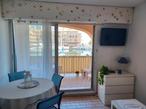 a living room with a table and a sliding glass door at La Gavine studio vue mer in Hyères