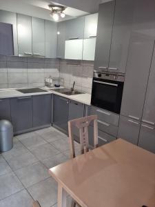 uma cozinha com uma mesa e uma cadeira em Empire Apartments em Skopje