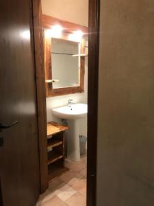 La salle de bains est pourvue d'un lavabo et d'un miroir. dans l'établissement Relais La Font, à Castelmagno