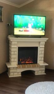 a tv sitting on top of a fireplace with a tv above it at Pod evkaliptom Apartment in Gagra