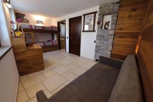 uma sala de estar com um sofá e uma parede de pedra em Maison du Passage em Aosta