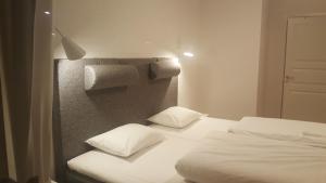 a bedroom with two white beds and a wall at SJÖTORPS HOSTEL in Sjötorp