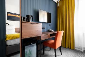 a room with a desk with a chair and a bed at Hotel Vestina in Wisła