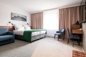 ヴィスワにあるHotel Vestinaのベッドとデスクが備わるホテルルームです。