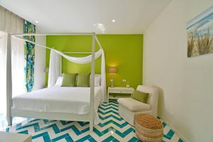 - une chambre avec un lit à baldaquin et une chaise dans l'établissement Luxury Suites Casa di Joy in Cefalù, à Cefalù