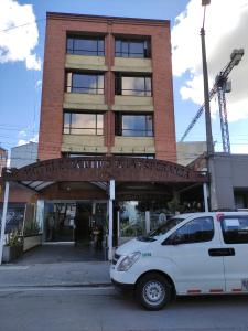 une camionnette blanche garée devant un bâtiment dans l'établissement Hotel Ejecutivo Av la Esperanza, à Bogotá