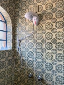 El baño incluye ducha con cabezal en una pared de azulejos. en Casa da Vó Diva no Centro de Gramado en Gramado