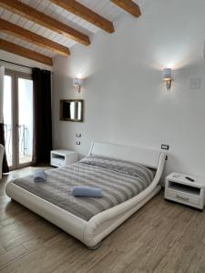 a white bedroom with a large bed and a window at L’ANGELO BIANCO in Pula