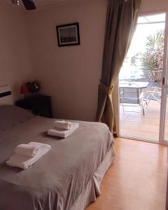 1 dormitorio con 1 cama con toallas en Posada El Alamo Mendoza en Mendoza
