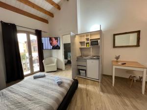 a bedroom with a bed and a desk and a tv at L’ANGELO BIANCO 2 in Pula