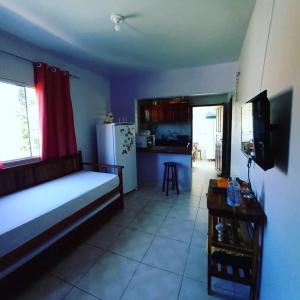 ein Wohnzimmer mit einem Bett und eine Küche in der Unterkunft Pousada Triplex Pôr Do Sol in Flecheiras