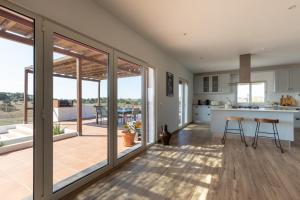 a kitchen with sliding glass doors leading to a patio at Monte das Mós in Ourique