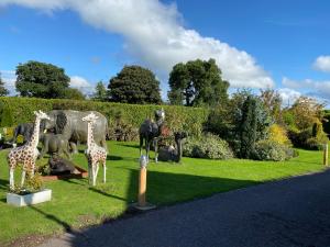 a statue of giraffes and other animals in a field at The Hilltop Haven in St Asaph