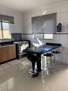 a kitchen with a black table and chairs in it at Casa Oliveiras in Itajaí