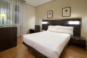 a bedroom with a large white bed in a room at Hotel Sercotel Tudela Bardenas in Tudela