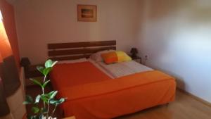 ein Schlafzimmer mit einem Bett mit einer orangefarbenen Decke in der Unterkunft Apartmán Danka in Banská Bystrica